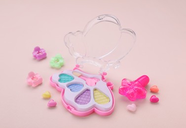Photo of Decorative cosmetics for kids. Eye shadow palette and accessories on pink background