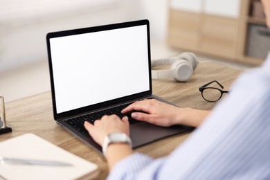 Woman watching webinar at wooden table in office, closeup