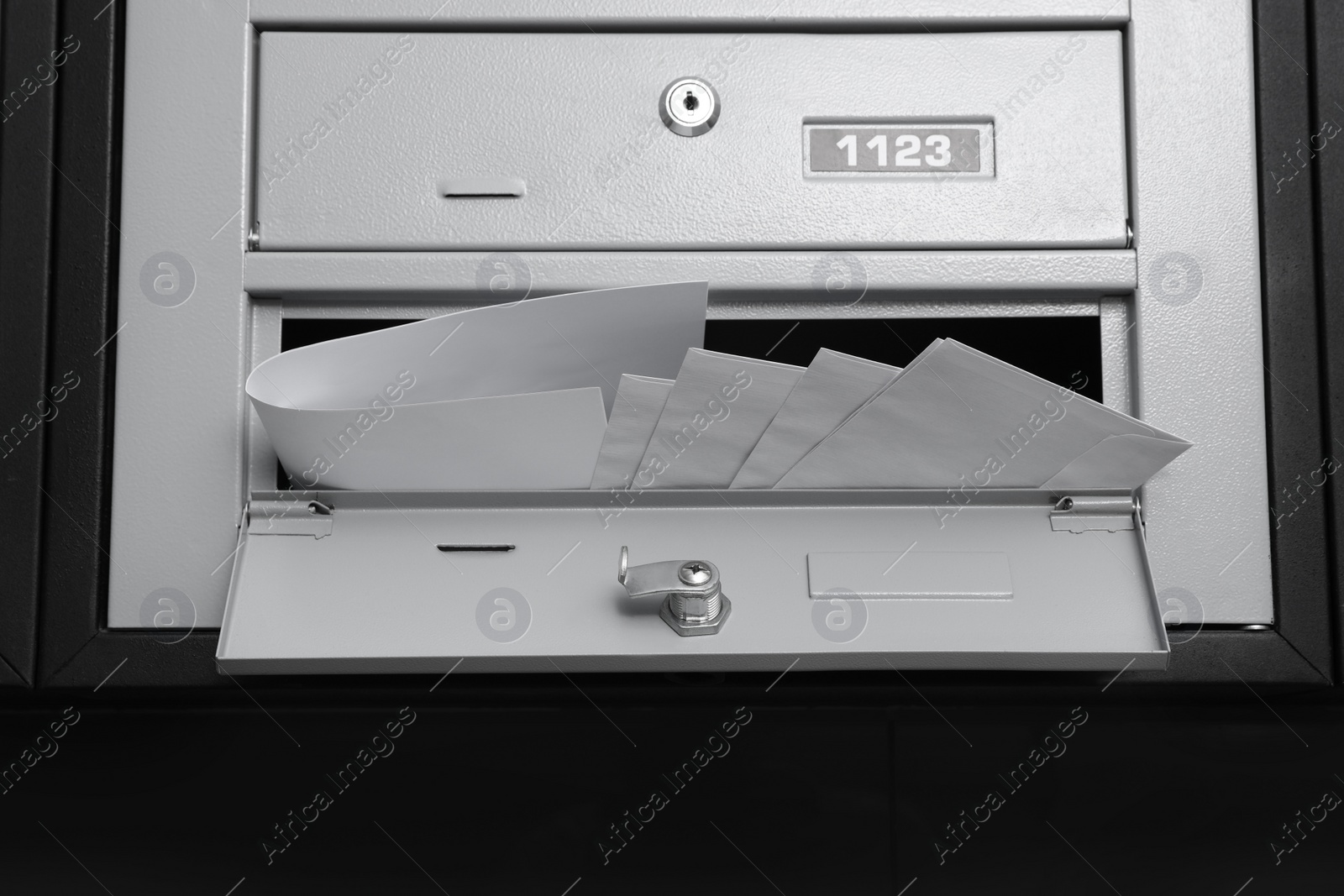 Photo of Open grey metal mailbox with envelopes indoors