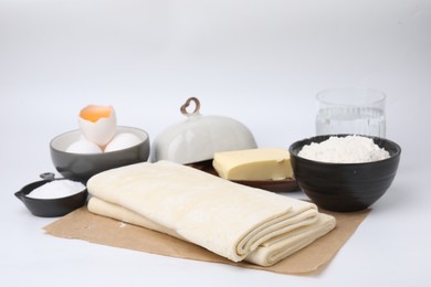 Raw puff pastry dough and ingredients isolated on white