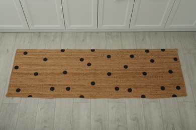 Photo of Stylish rug with dots on floor in kitchen, above view
