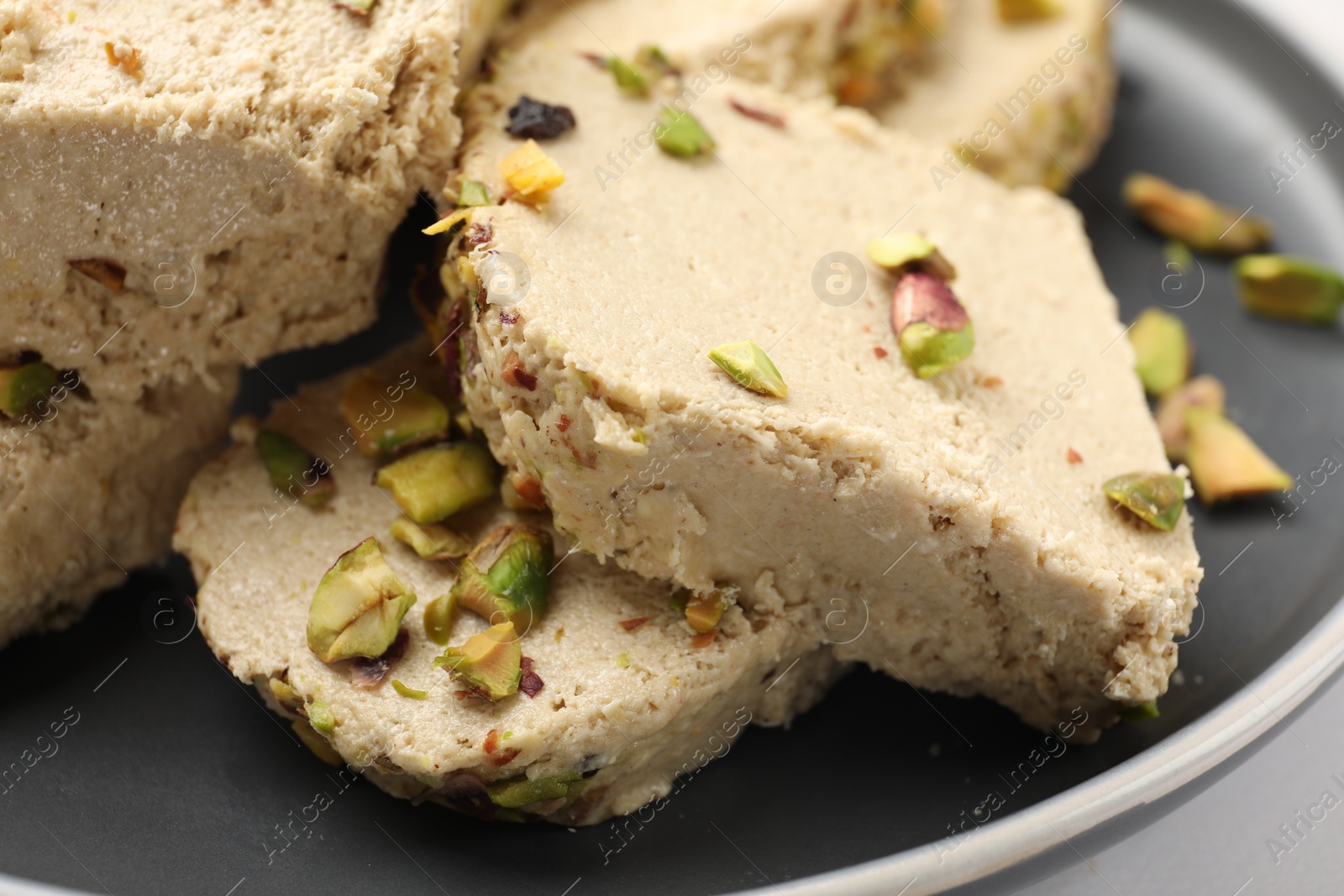 Photo of Tasty pistachio halva on white table, closeup