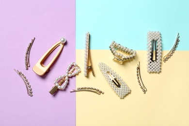 Stylish hair clips on color background, flat lay
