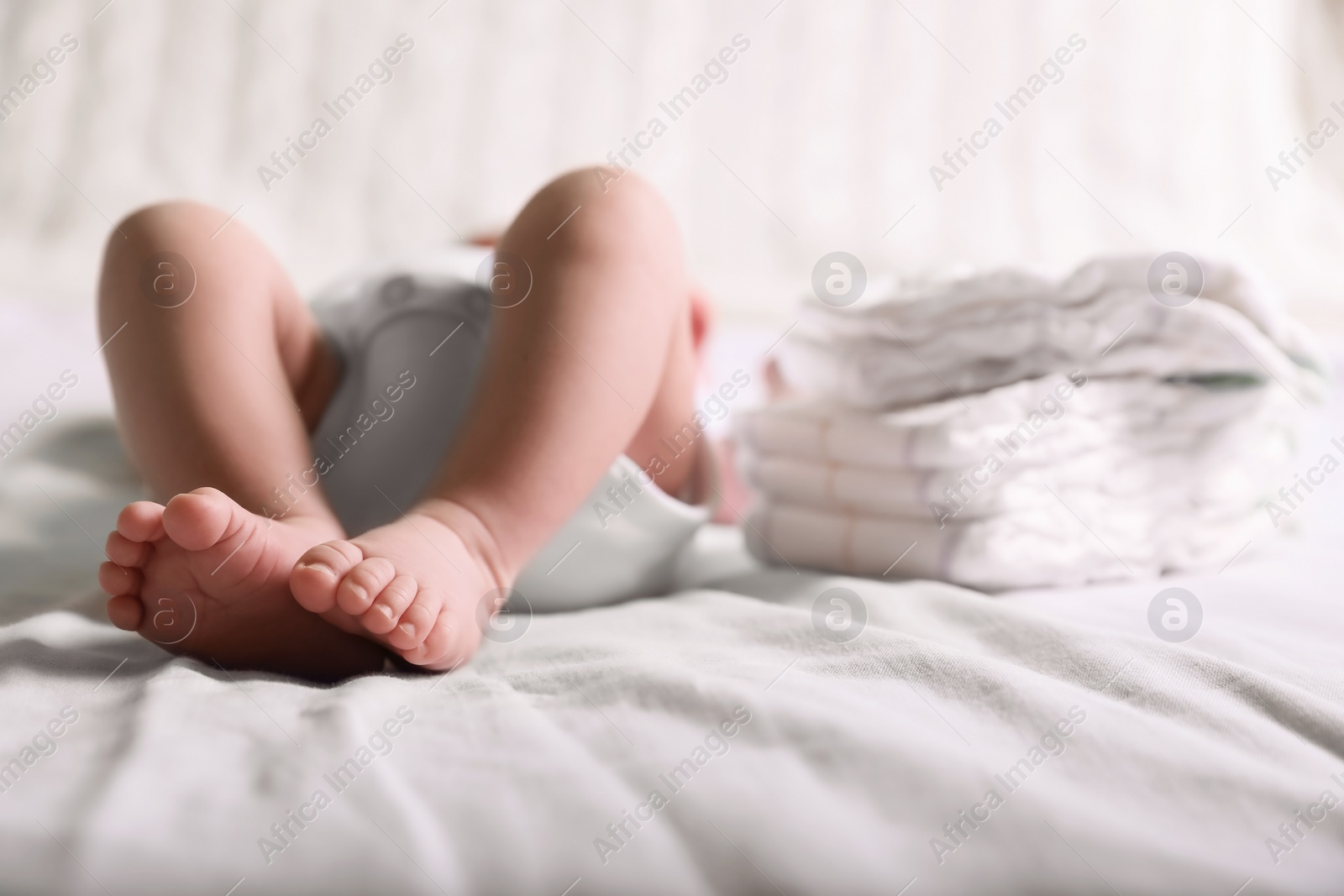 Photo of Little baby lying at bed, focus on legs