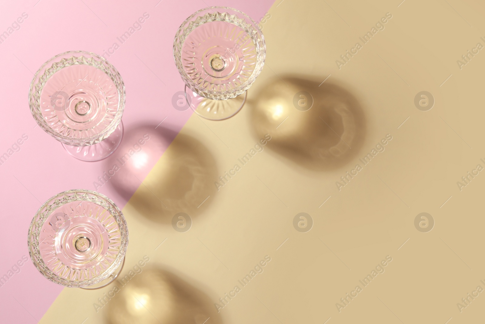 Photo of Glasses of expensive white wine on color background, flat lay. Space for text
