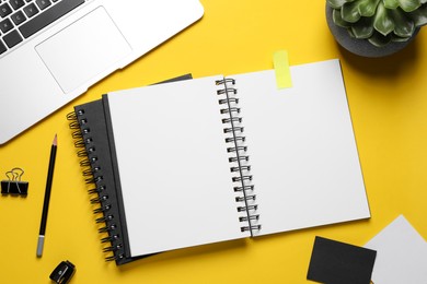 Photo of Flat lay composition with stylish notebooks on yellow background