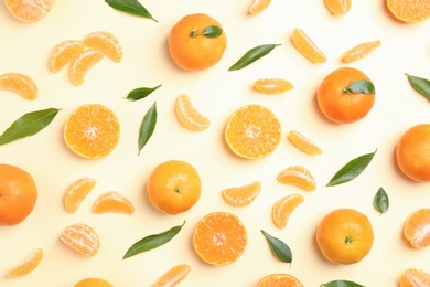 Photo of Composition with tangerines and leaves on color background, flat lay