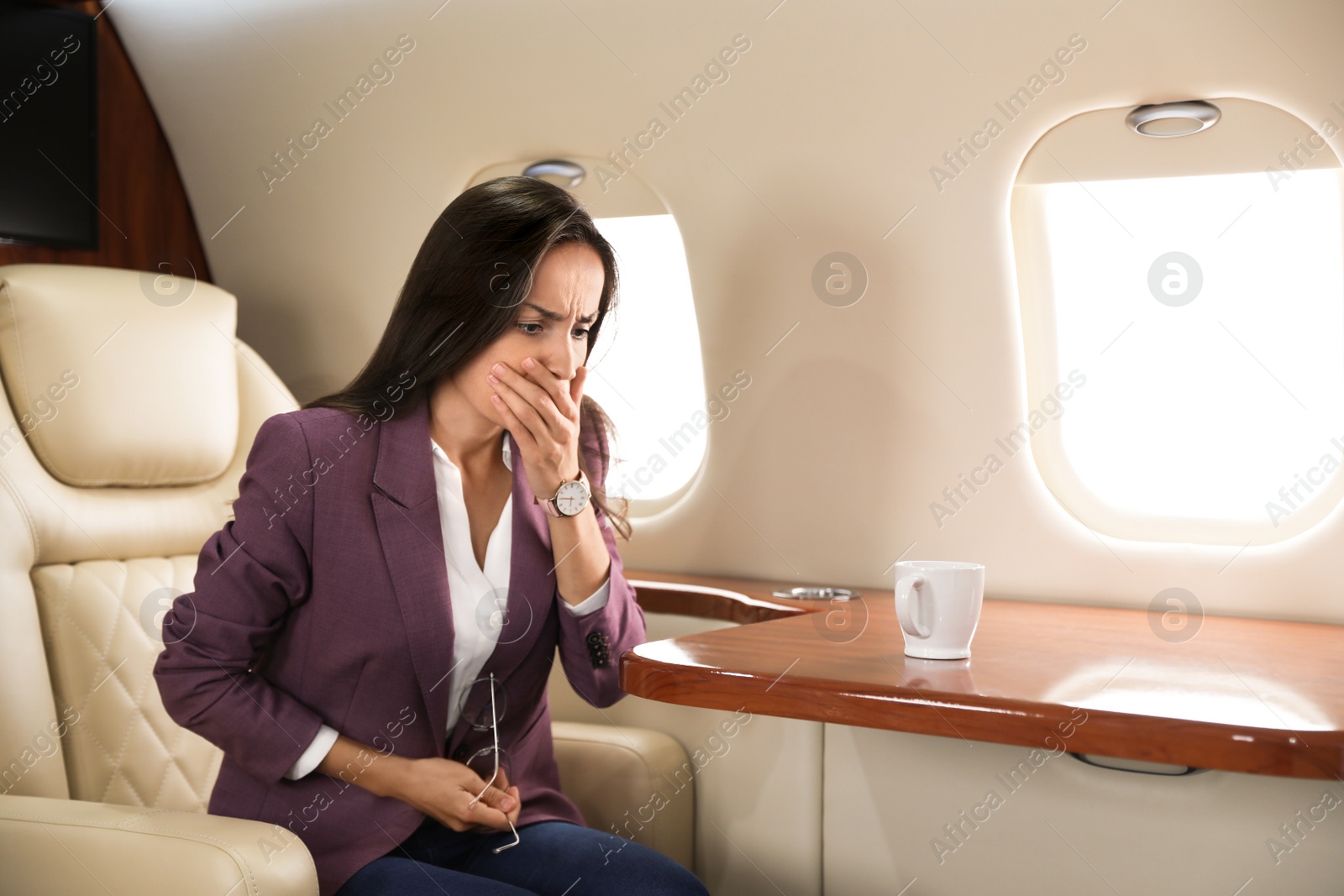 Photo of Young business woman feeling sick during flight