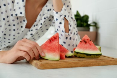 Photo of Teenage girl with slices of watermelon at countertop in kitchen, closeup
