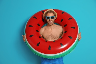 Photo of Happy young man with inflatable ring on color background