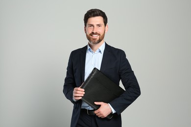 Photo of Handsome real estate agent with documents on grey background