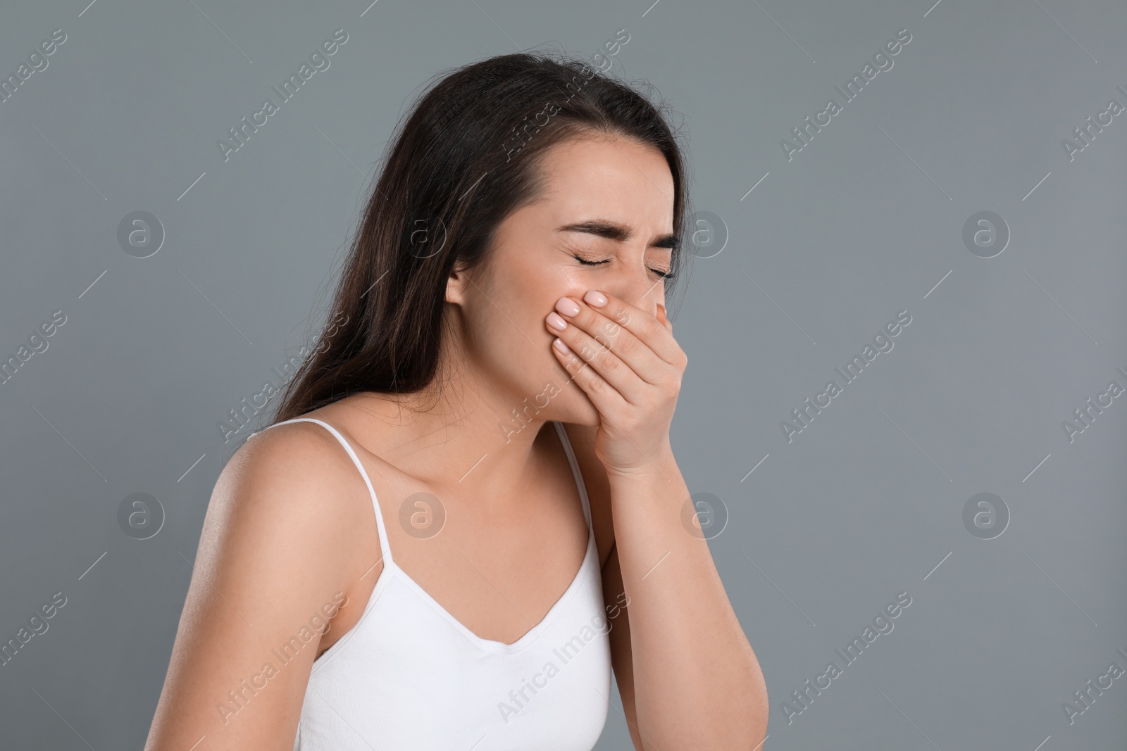 Photo of Young woman suffering from nausea on grey background. Food poisoning