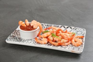 Photo of Delicious shrimp cocktail with tomato sauce on grey table