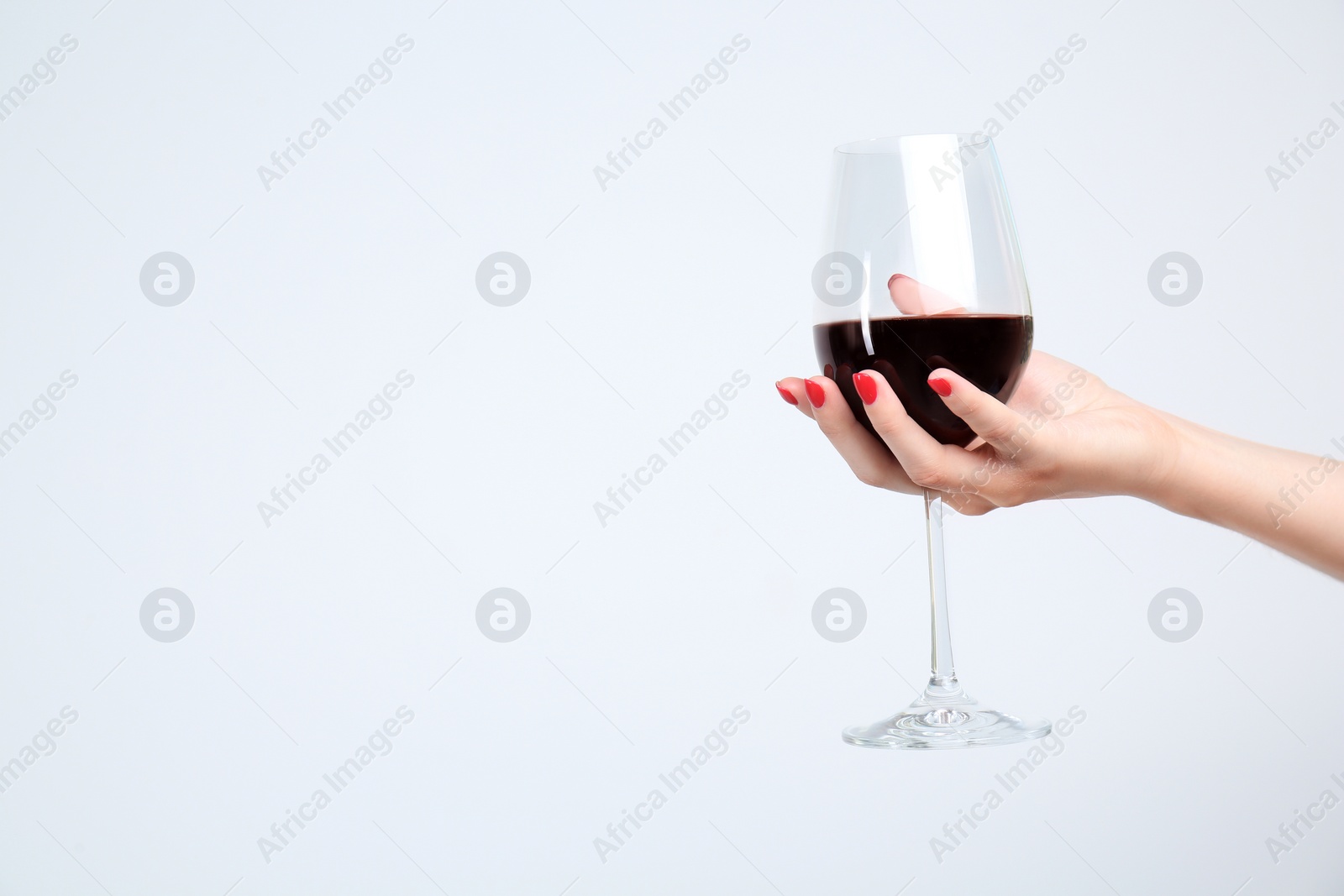 Photo of Woman holding glass of red wine on white background