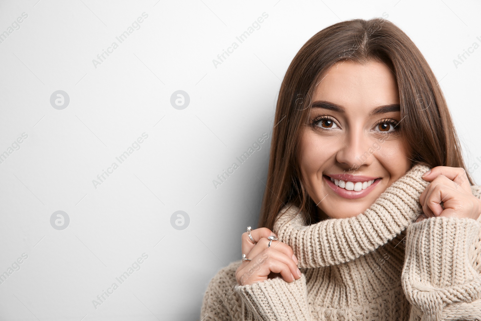 Photo of Beautiful young woman in warm sweater on white background. Space for text