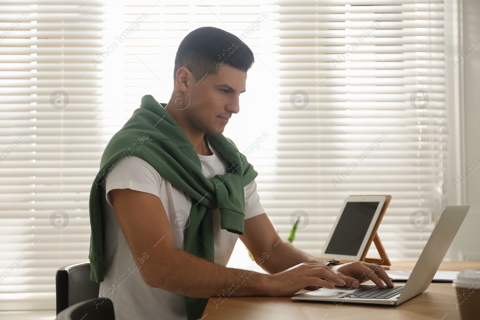 Photo of Freelancer working on laptop at table indoors