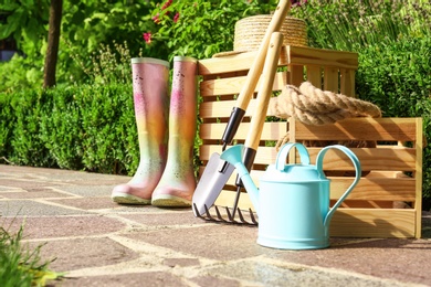 Wooden crates and gardening tools on stone path at backyard