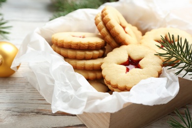 Traditional Christmas Linzer cookies with sweet jam in wooden crate on table