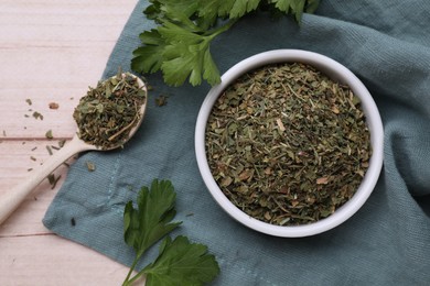 Photo of Dried aromatic parsley and fresh leaves on white wooden table, flat lay