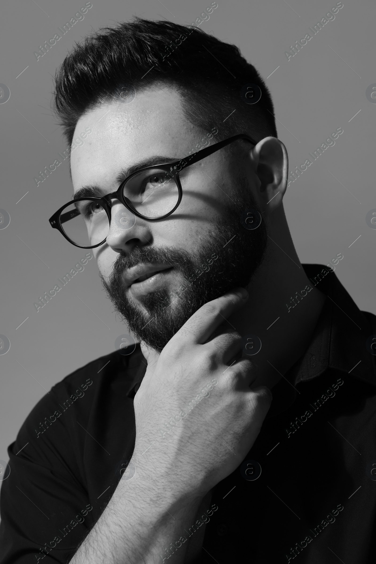 Photo of Portrait of handsome bearded man on grey background. Black and white effect