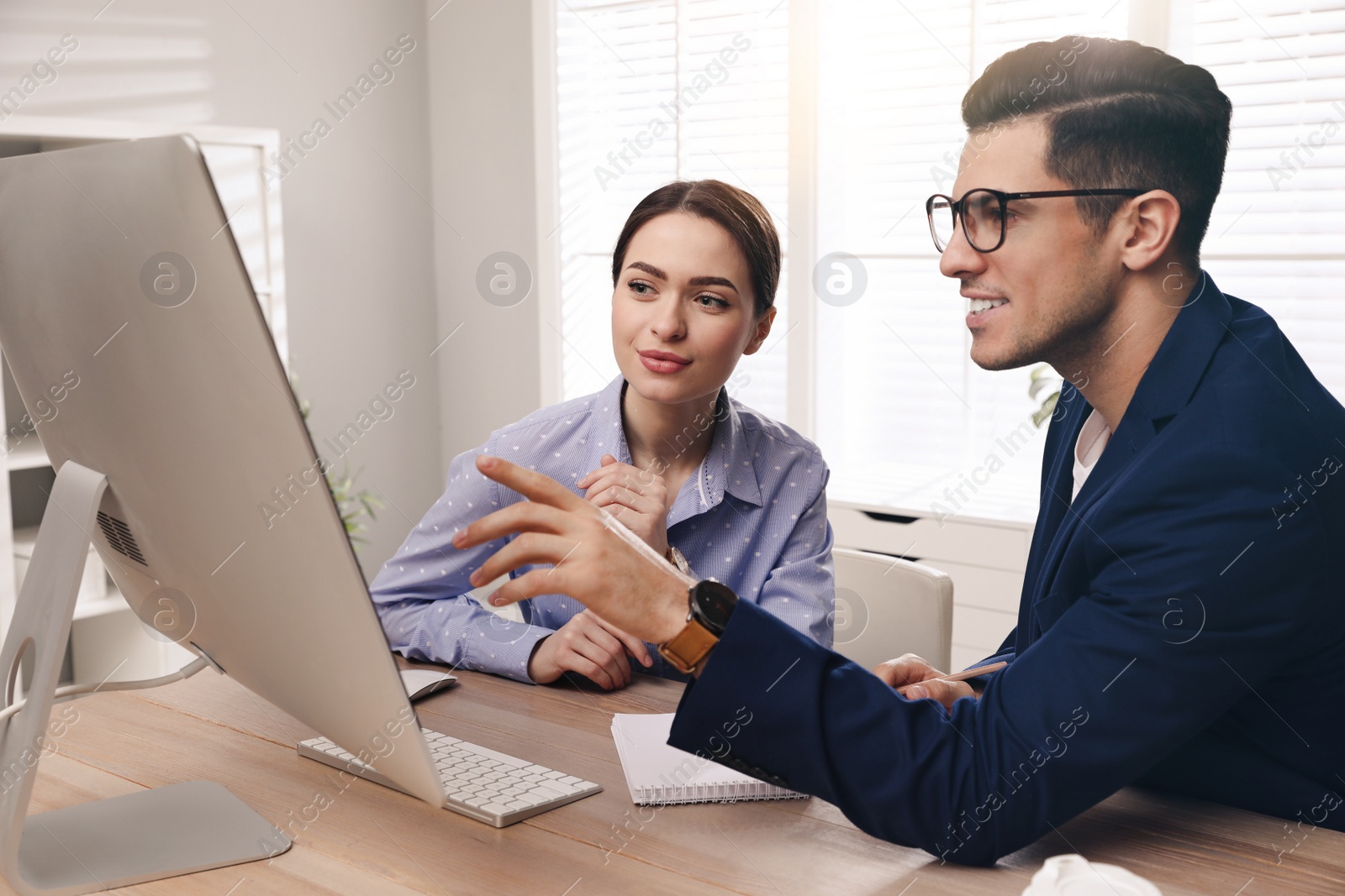 Photo of Businessman helping intern with work in office