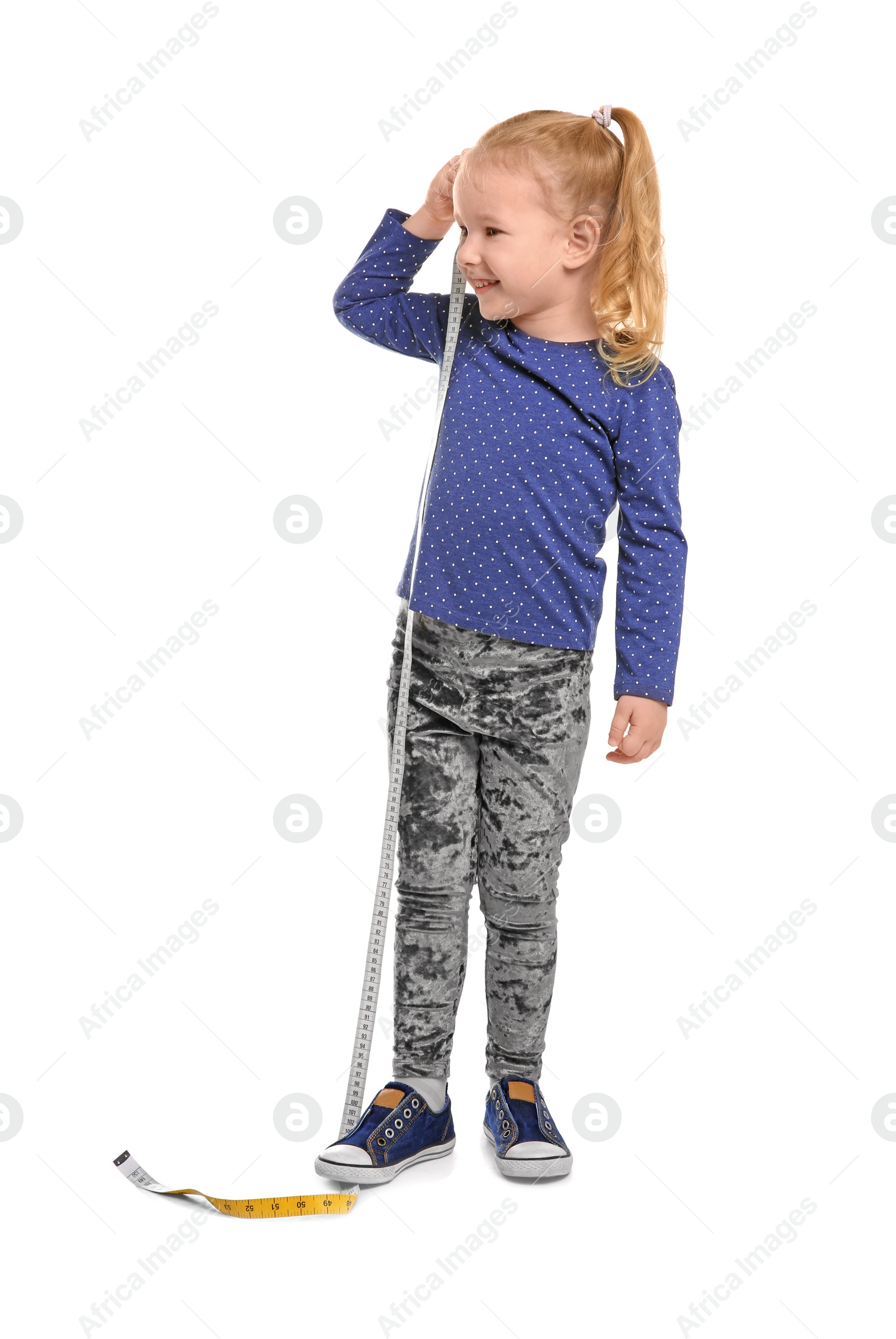 Photo of Little girl measuring her height on white background