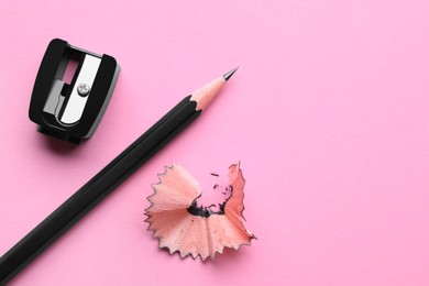 Pencil, sharpener and shavings on pale pink background, flat lay. Space for text