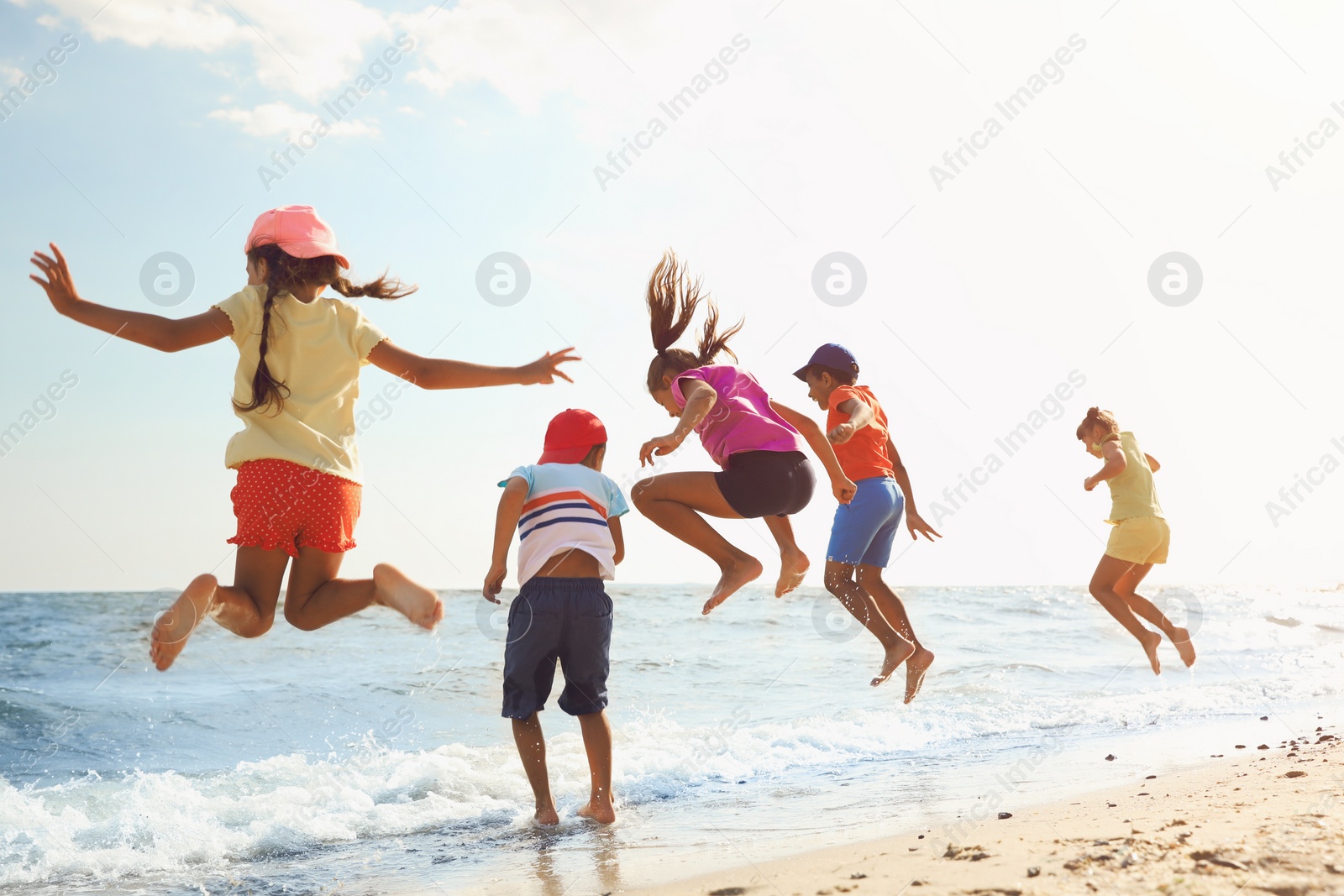 Photo of Cute children enjoying sunny day at beach. Summer camp