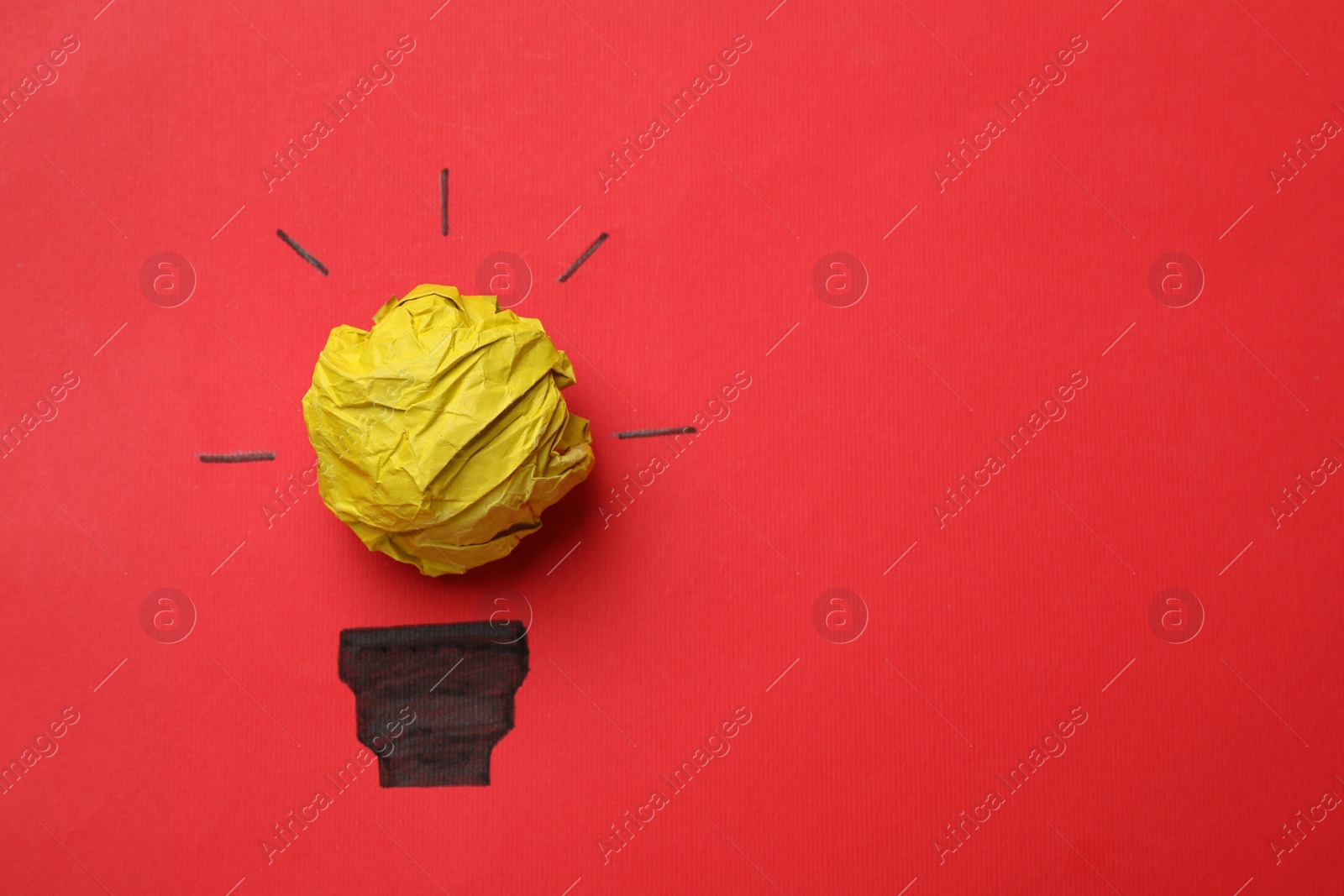 Photo of Idea concept. Light bulb made with crumpled paper and drawing on red background, top view. Space for text