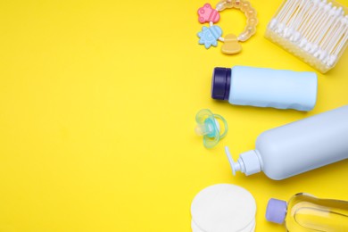 Photo of Flat lay composition with baby care products and accessories on yellow background, space for text