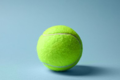 One tennis ball on light blue background
