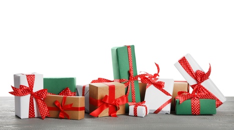 Many different Christmas gifts on grey wooden table against white background