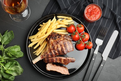 Image of Tasty grilled steak served on black table, flat lay