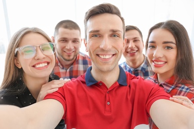 Happy friends taking selfie indoors