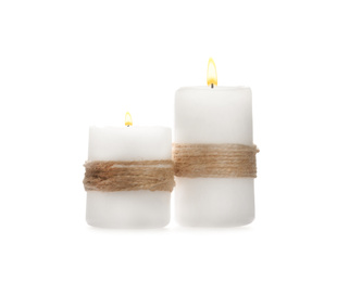 Wax candles decorated with twine isolated on white