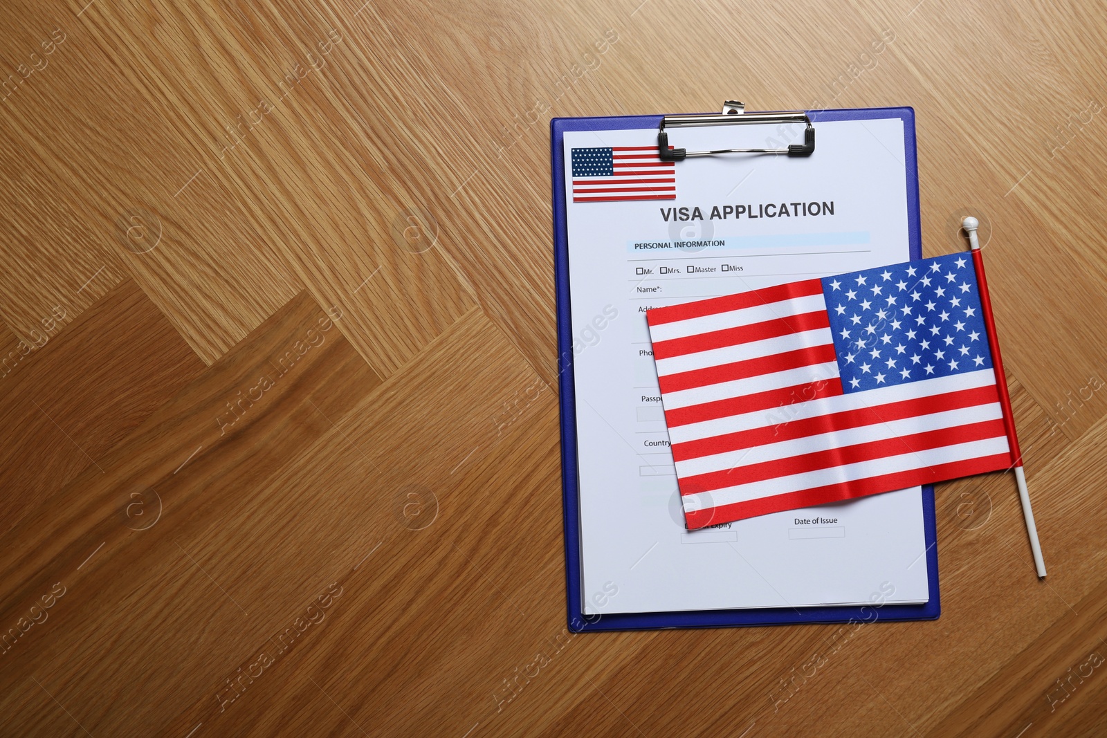 Photo of Visa application form and small American flag on table, flat lay. Space for text
