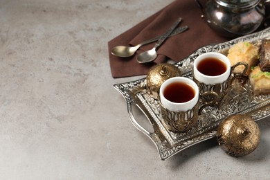 Tea and baklava served in vintage tea set on grey table, space for text
