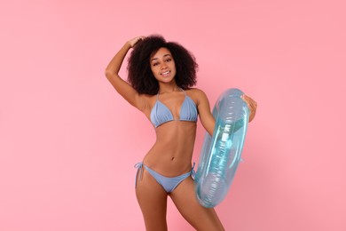 Photo of Beautiful woman in stylish bikini with inflatable ring on pink background