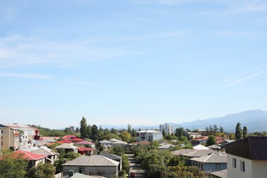 Picturesque view of cityscape and mountains under blue sky