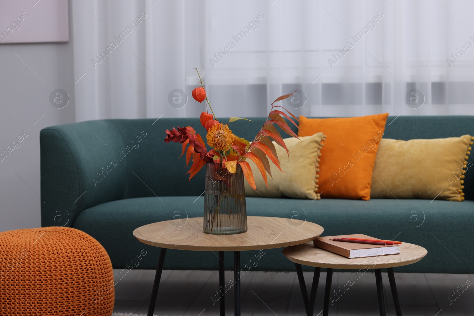 Photo of Comfortable sofa and nesting tables in living room. Stylish interior design