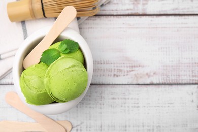 Tasty matcha ice cream in bowl on white wooden table, flat lay. Space for text