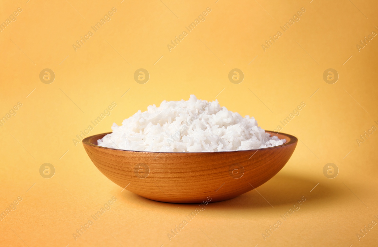 Photo of Bowl of boiled rice on color background