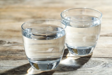 Glasses of water on wooden table. Refreshing drink