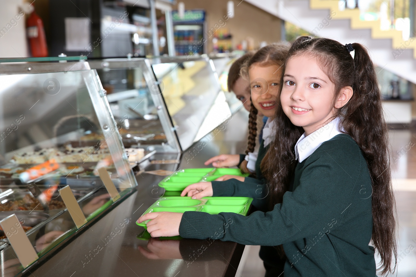 Photo of Children near serving line with healthy food in school canteen