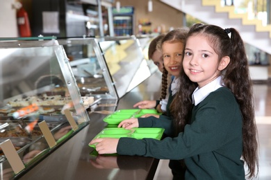 Children near serving line with healthy food in school canteen
