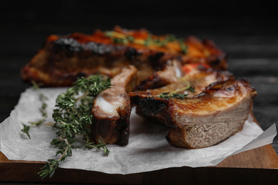 Photo of Tasty grilled ribs with thyme on table, closeup