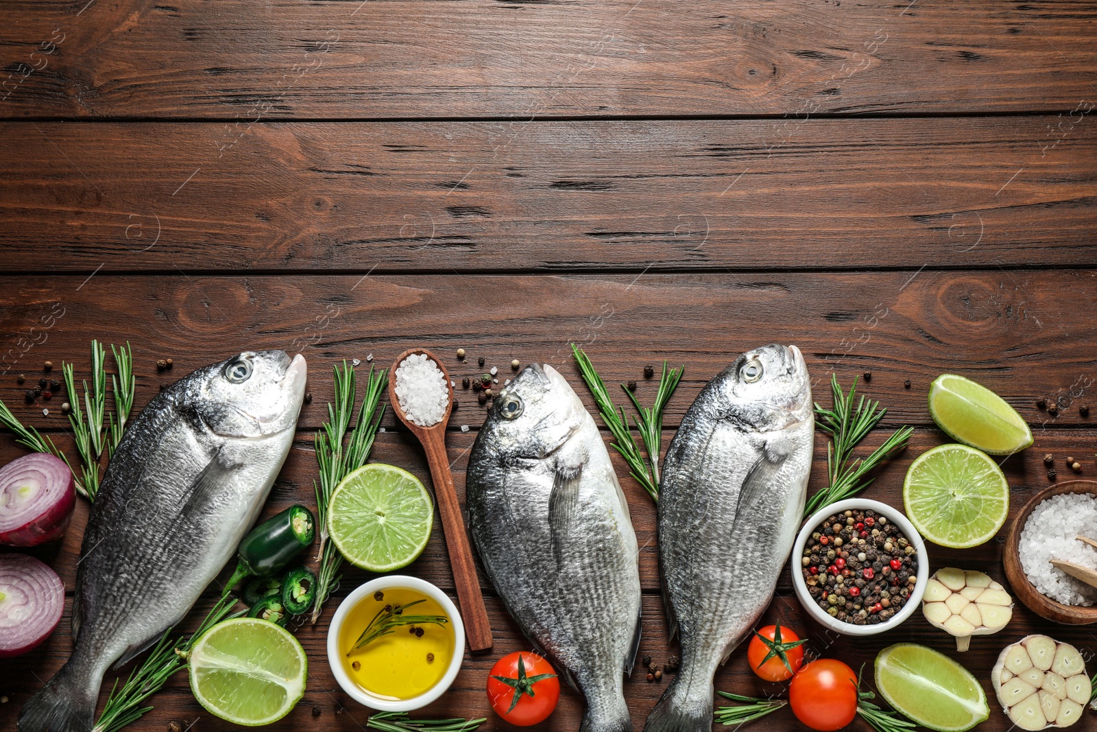 Photo of Flat lay composition with raw dorada fish on wooden table, space for text