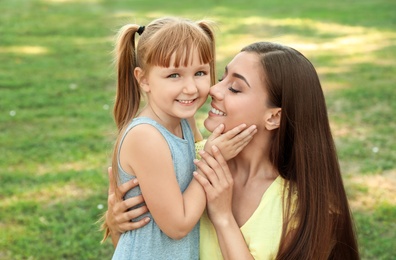 Photo of Mother with her cute child in green park on sunny day. Happy family