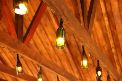 Photo of Creative pendant lamps with light bulbs indoors