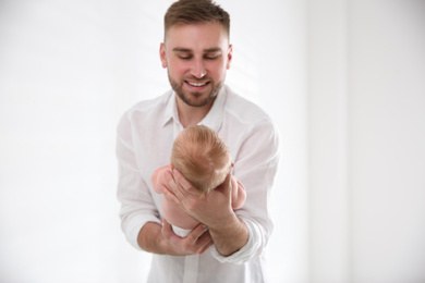 Photo of Father with his newborn son on light background